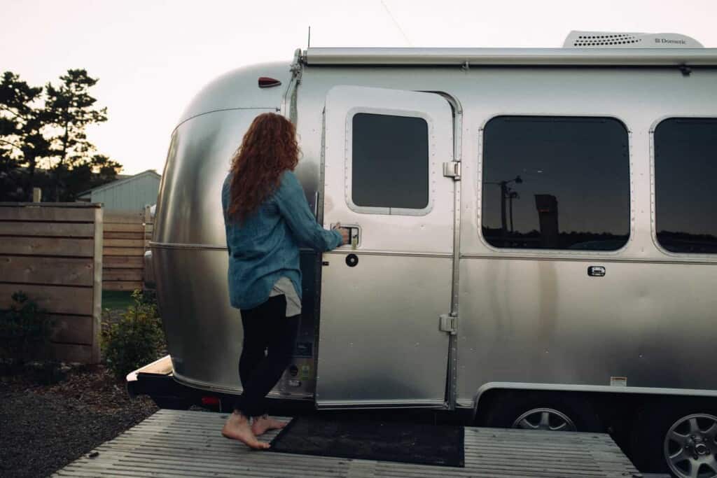 Lady walking into an Airstream trailer