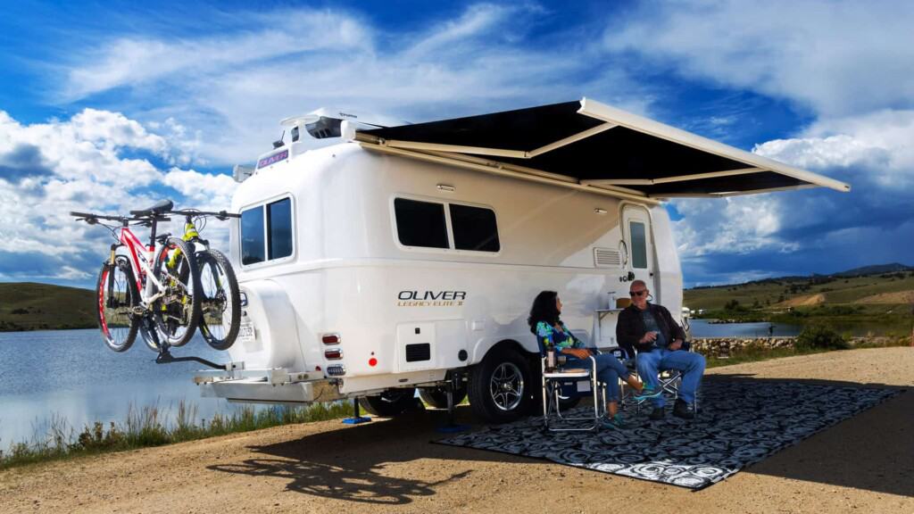 Couple camping by a lake with Oliver Legacy Elite 2 (Image: Oliver Travel Trailers)
