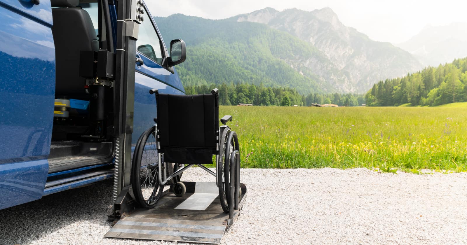 Empty wheelchair on a ramp of a campervan with nature and mountains in the background, RV modifications for disabilities are what help folks get out and travel