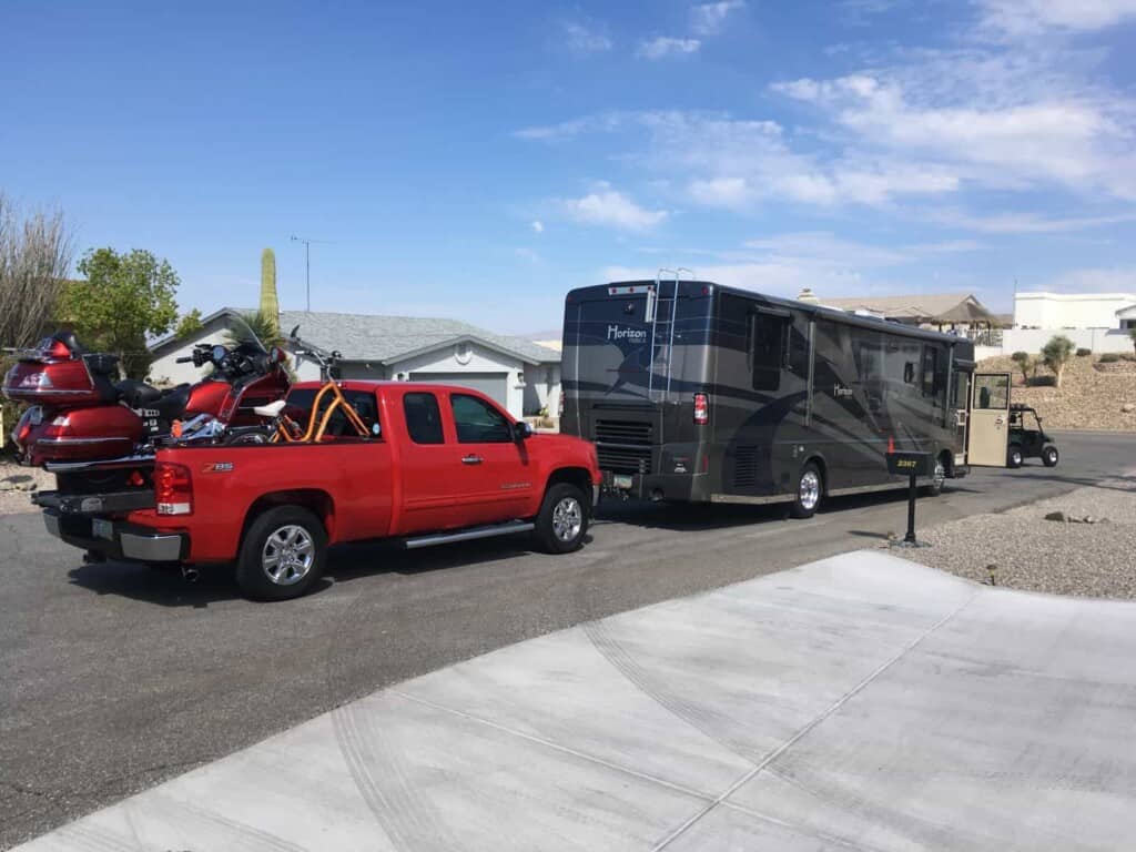 flat towing truck and motorcycle behind motorhome