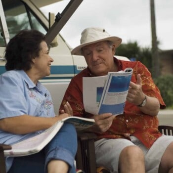 mature couple reading magazine in front of motorhome (Image: Shutterstock)