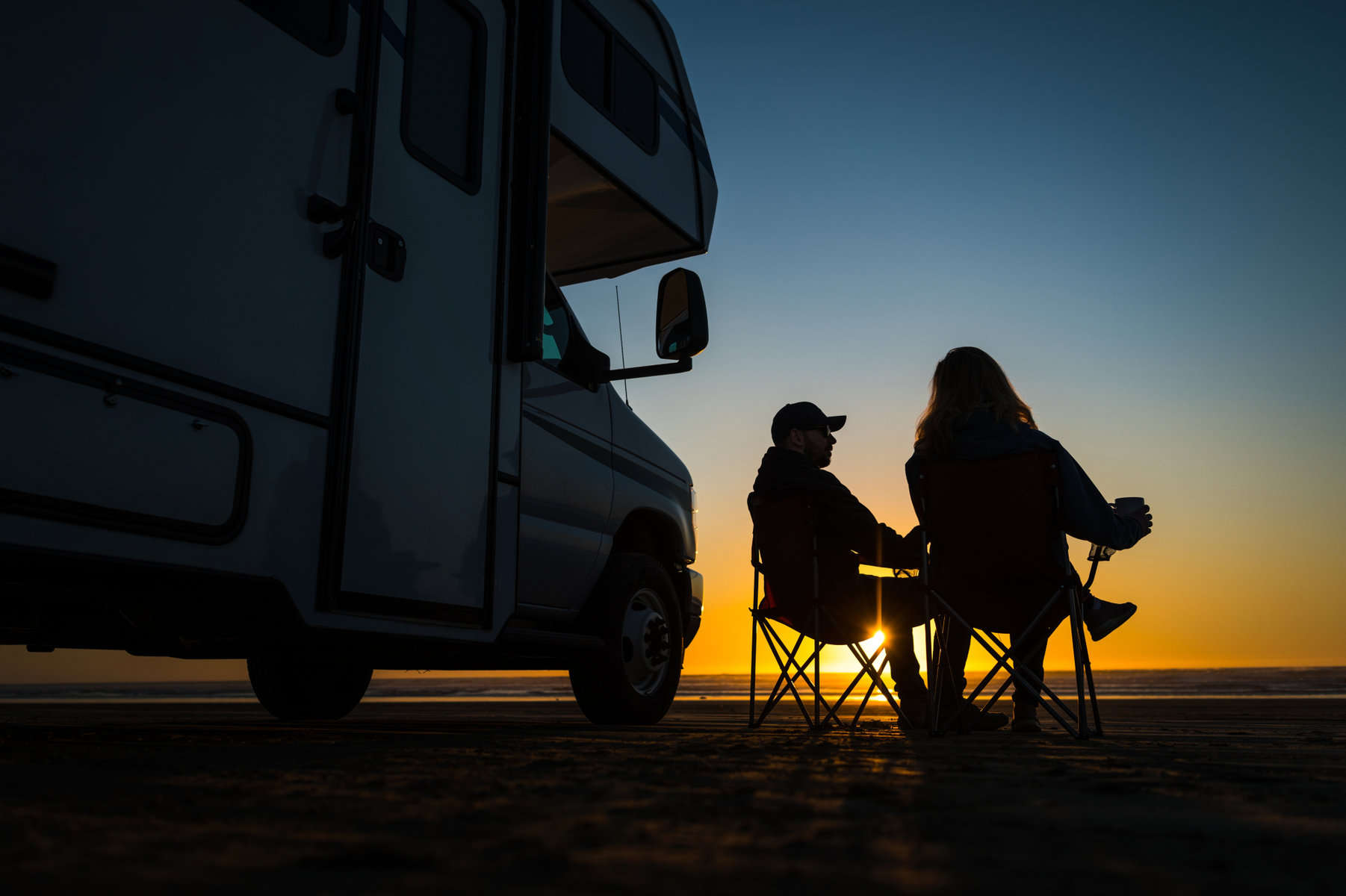 silhouette RV couple next to motorhome at sunset (Image: Shutterstock)